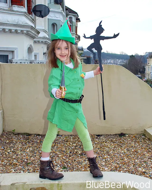 Girl dressed as Peter Pan holding a paper shadow and handmade dagger for a World Book Day costume