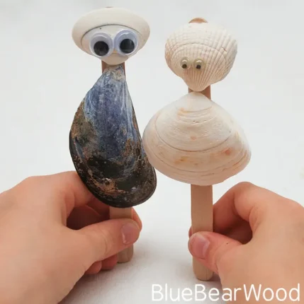 Handmade seashell puppets with googly eyes on wooden sticks