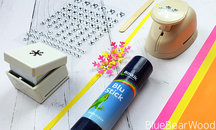 Materials Required To Make Tropical Snowflake Bracelets - Bostik Blu Stick - Bright Coloured Paper - Snowflake Punches - yellow Ribbon - Stick On Gems